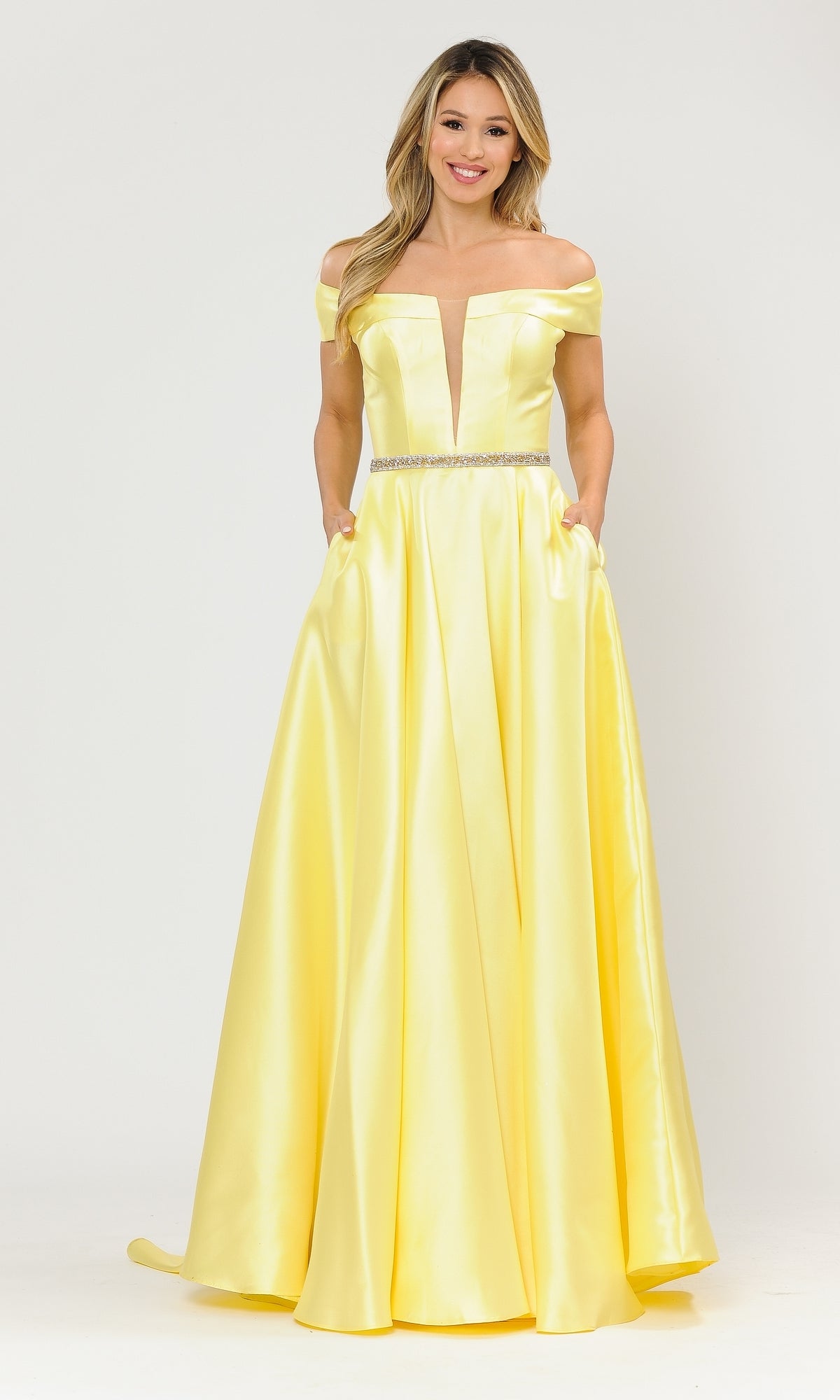 A woman stands against a plain white background wearing the Plunging V-Neck Long Mikado Prom Ball Gown 8680 in yellow, featuring a floor-length skirt, off-the-shoulder fitted bodice, side pockets, and a jeweled belt.